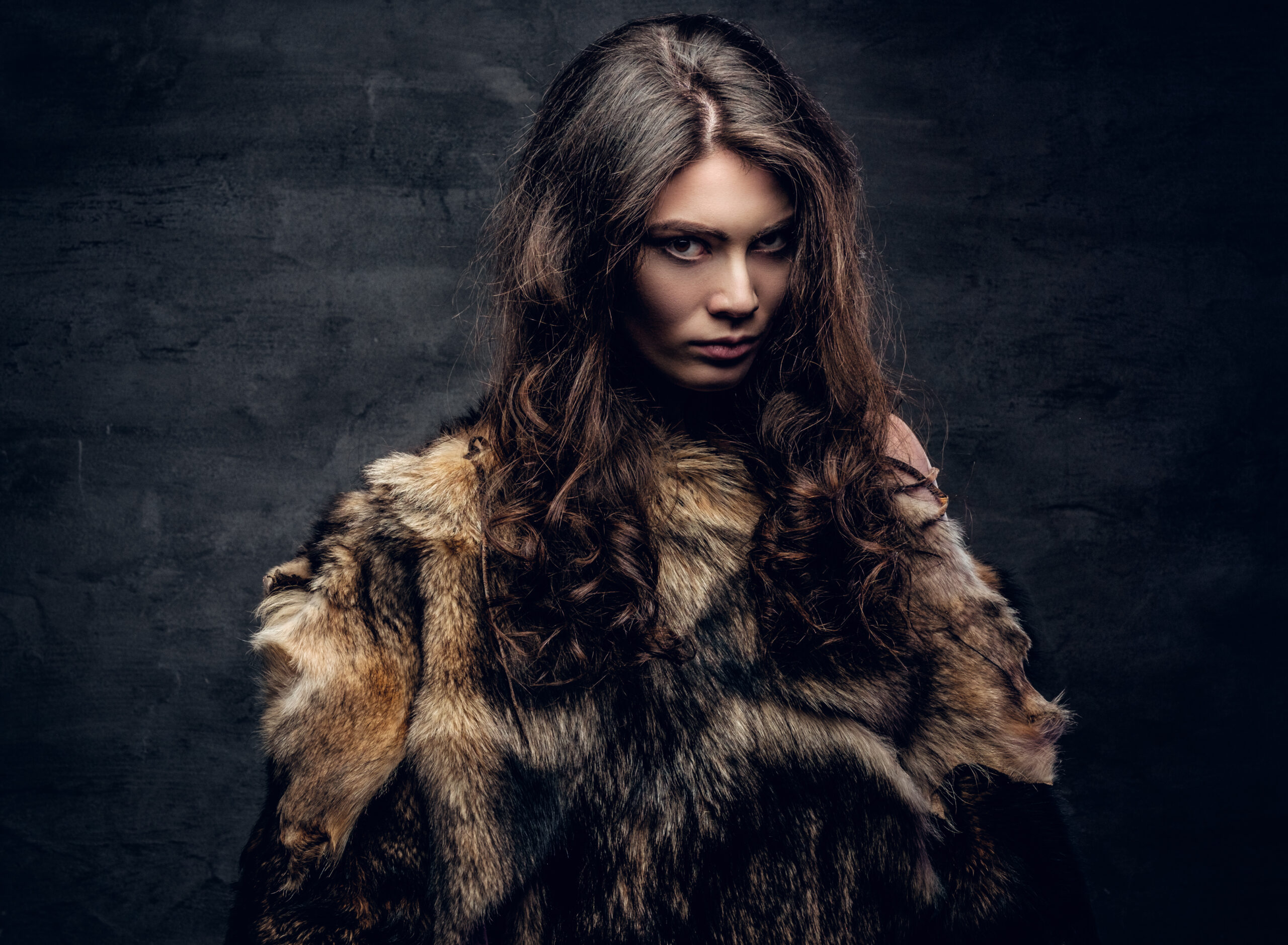 Sensual brunette female dressed in a fur coat.